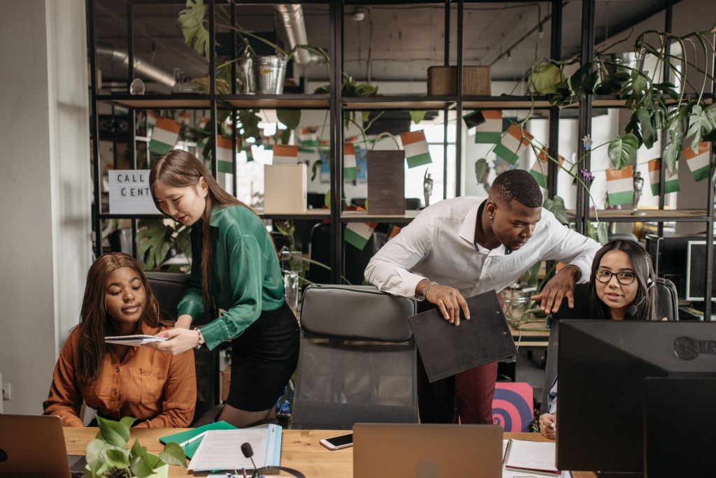 Grupo diverso de trabalhadores colaborando em um ambiente de call center.