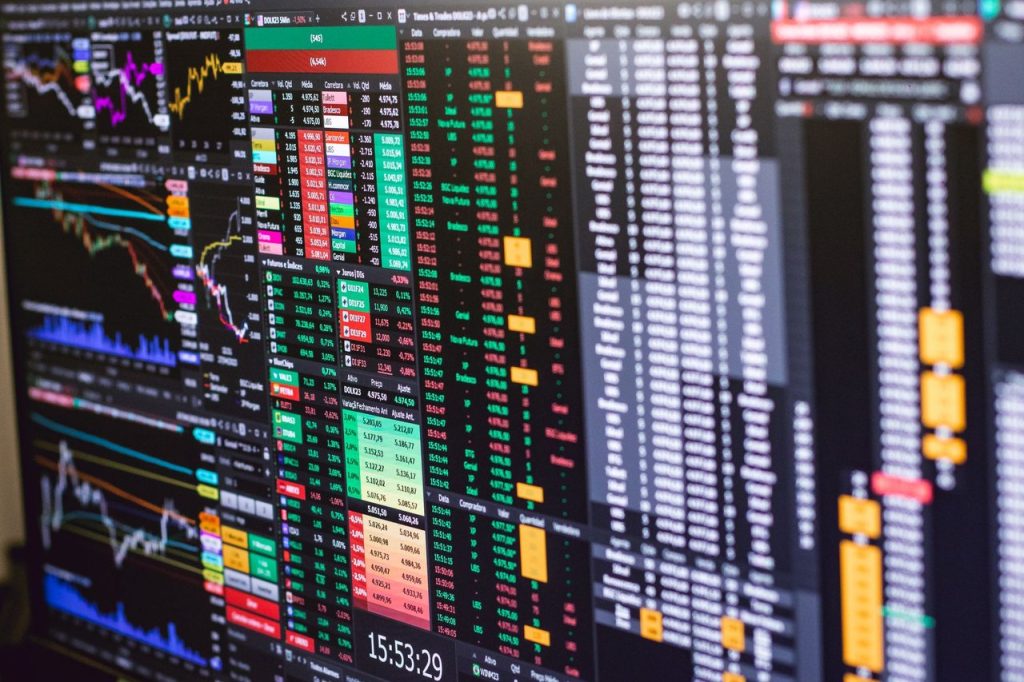 Tela de negociação financeira com gráficos coloridos e dados de mercado.
